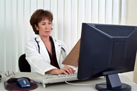Physician entering notes with a traditional keyboard Physician entering notes with a traditional keyboard